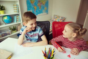 Two cute children drawing with colorful pencils