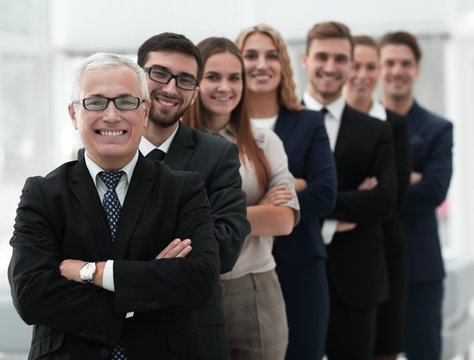 senior businessman standing in front of his business team