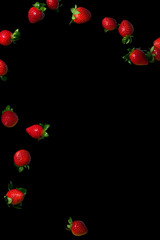 Strawberries in the air. Juicy ripe berries on a black background