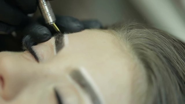 Close up of cosmetologist making microblading procedure.