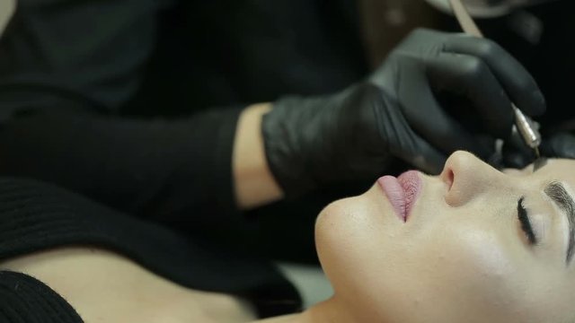 Microblading procedure. Master works with the eyebrows.