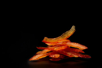 Tasty candied orange peel - macro foto, isolated on a black with place for a text.