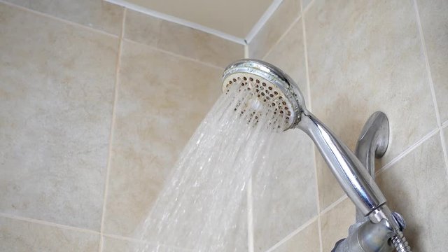 Well used shower. Running water shower fauset. Water stream.