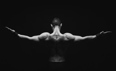 Obraz na płótnie Canvas Unrecognizable man shows strong back muscles closeup