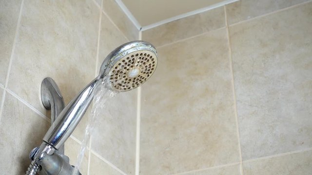 Well used dirty shower head. Running water shower fauset. Water stream.