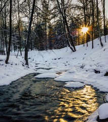 Calm Winter Photo of a Partly Frozen River with a Sun Shining in Camera -  Sun Flare