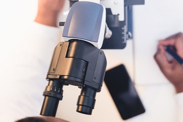 close up of man using microscope