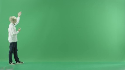 The child is going from the left side and showing the weather forecast on the green screen