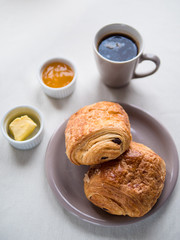 Continental breakfast with French chocolate croissants, butter, jam and black coffee