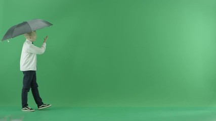 The child is going from the left side and showing the weather forecast with umbrella on the green screen