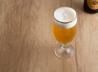Glass of craft beer on wooden table