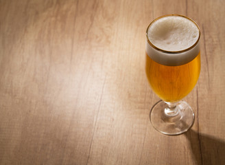 Glass of craft beer on wooden table