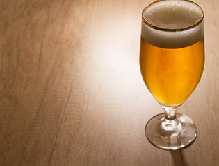 Glass of craft beer on wooden table