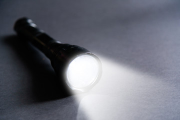 Flashlight and beam of light on a dark background