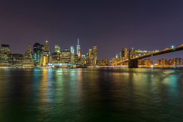 Naklejka na ściany i meble View on skyscrapers in lower Manhattan from Brooklyn skyline in New York City at night.