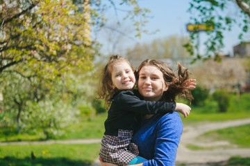 Fototapeta premium The girl hugs Mom. The child is in the mother's arms.