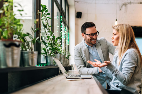 Side View Of Two Young Business People Having A Successful Meeting At Restaurant.