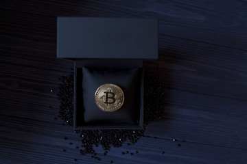 Golden bitcoin in a black box. Gold coin of cryptocurrency.