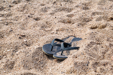 Flip flops on beach sand / Slippers on sandy beach vacation time, summer holiday background /...