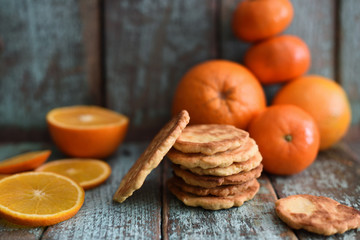 Homemade imperfect cookies with organic oranges and clementines on shabby blue wooden background