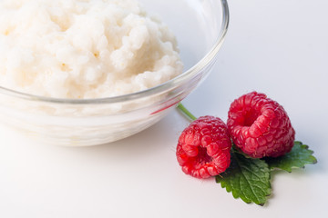 Milk Rice porridge with raspberry, white background light key