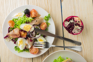 Fresh salad with mixed greens and cherry tomato in bowl on wooden background