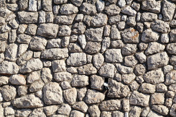 Natural contrast masonry wall stone granite is a pattern of texture, material and background with colored stones / Old brick wall as background wallpaper, close up / Decorative stones were arranged.