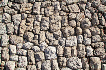 Natural contrast masonry wall stone granite is a pattern of texture, material and background with colored stones / Old brick wall as background wallpaper, close up / Decorative stones were arranged.
