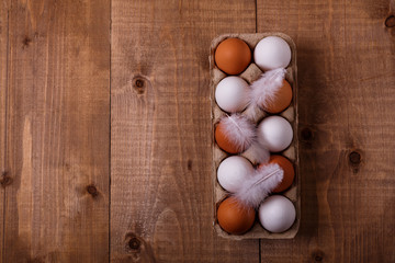 Eggs in pack on wooden table. Top view, text space