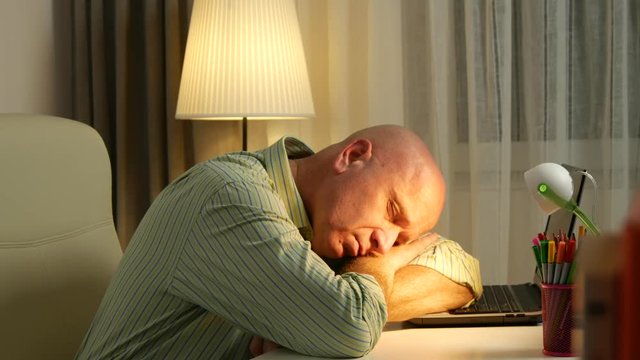 Businessman in Office Room Sleeping on the Desk Tired After a Long Working Day
