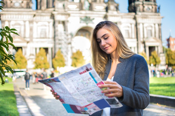 Young woman with map searching for city attraction outdoors. © Bojan