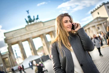 Fototapeten Beautiful young woman in smart casual wear talking on mobile phone outdoors. © Bojan