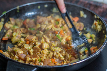 Cooking burrito in a pan with chicken, pepper, tomato for fajitas typical .Latin America food
