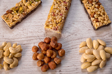 cereal sticks, healthy diet for lifestyle, ingredients - more nuts, dried plums, honey, oat flakes laid on the table