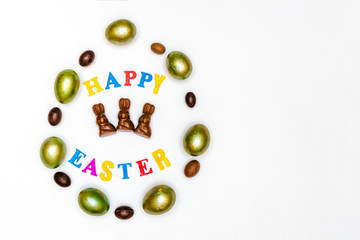 Easter composition of painted eggs and sweets and letters on a white background