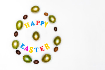 Easter composition of painted eggs and sweets and letters on a white background