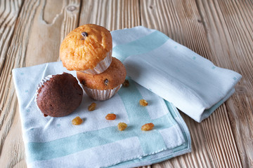 Multiple colorful nicely decorated muffins on a wooden background, top view