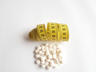 Pills and measuring tape for dieting concept and healthy diet