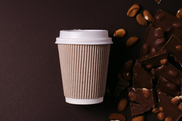 Take away coffee cup. Top view picture of hot drink and chocolate slices.