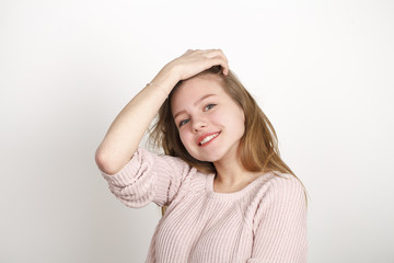 Close up portrait of pretty young schoolgirl with dark blonde hair smiling charmingly