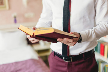 Young man in suit open and reading a book