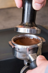 Tamper over fresh tamped coffee in portafilter to making espresso