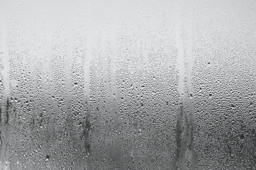 Background of natural water condensation, window glass with high air strong humidity, large drops drip. Collecting and streaming down