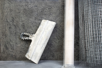 roll mesh for plastering, putty knife on the gray concrete background. Copy space. Top view.