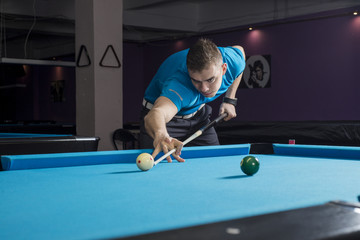 A low stance on a shot on a pool table with billiard player.