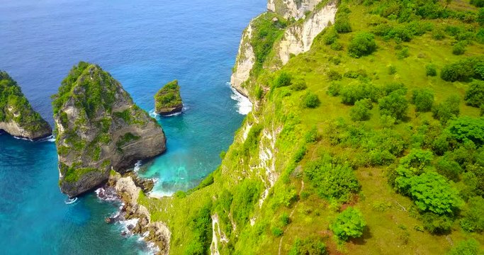 Zoom-Out Aerial View Of Coastal Cliff Ridge Overlooking Tropical Bay In Nusa Penida, Indonesia