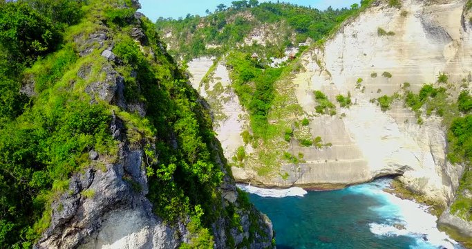 Panning View Of Coastal Cliff With Jungle Tree Houses In Background Ridge Overlooking Tropical Bay In Nusa Penida, Indonesia