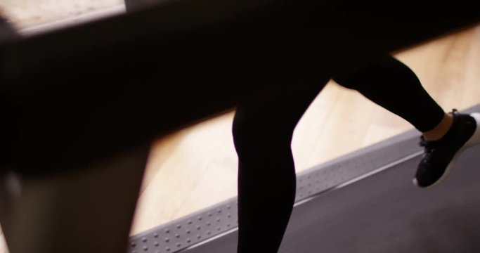 4K Panning Shot From Feet Upwards, Young Asian Woman Running On Treadmill At Home. Slow Motion.