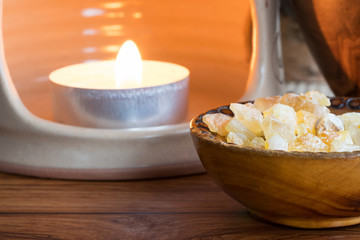 Frankincense resin in a bowl with a candle