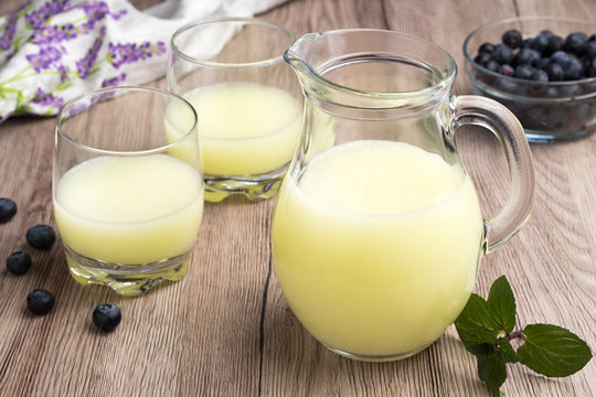 A jug of fresh whey with two glasses of whey
